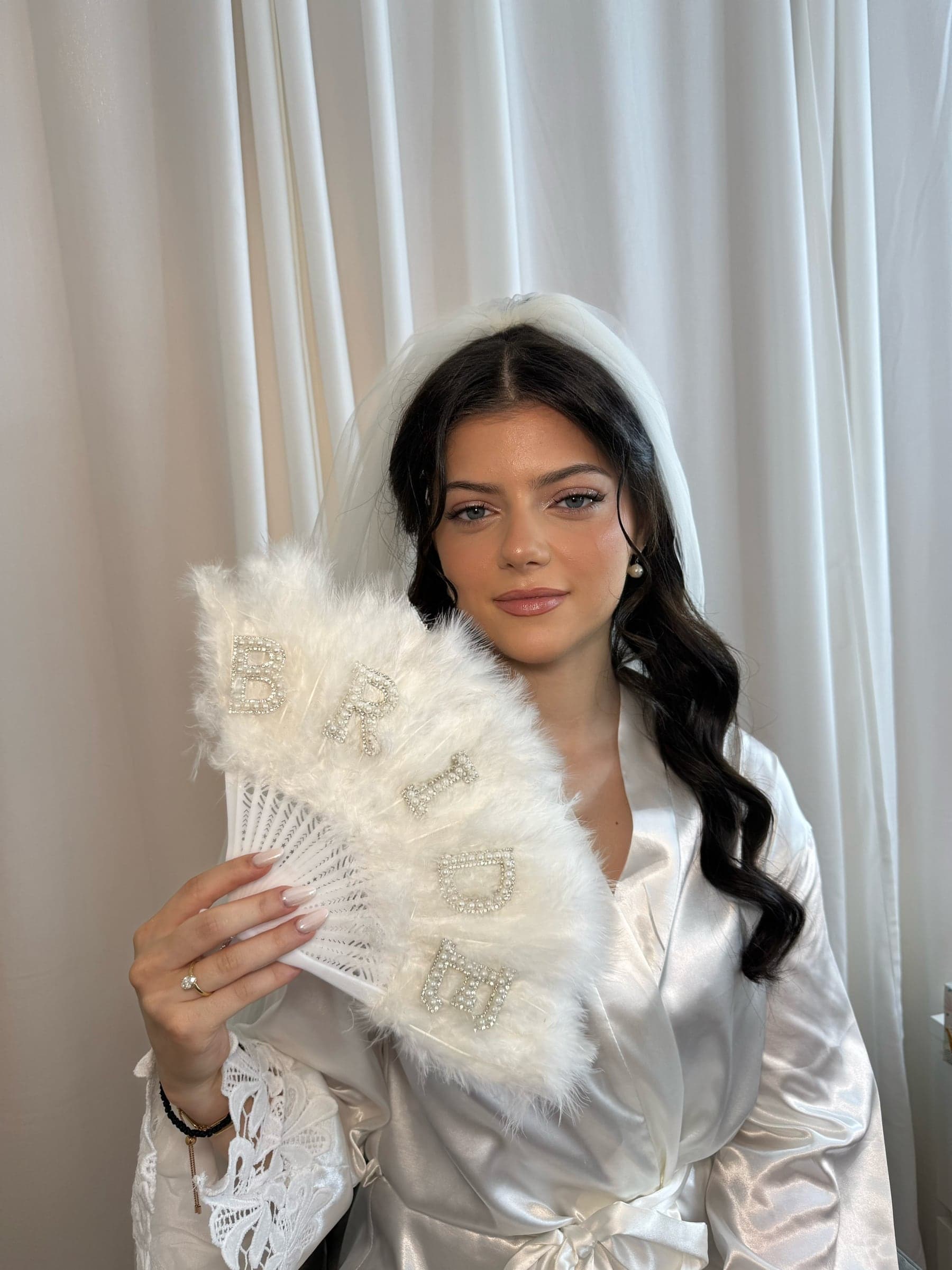 Bridal makeup look with veil and white fan